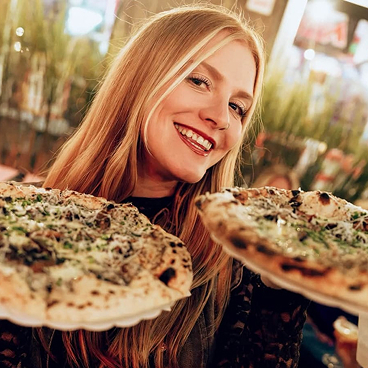 Jeune femme tenant deux pizza dans ses mains